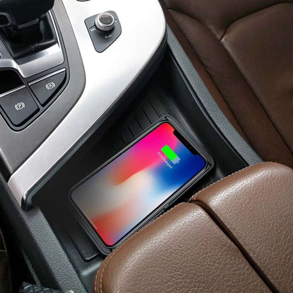 Smartphone charging wirelessly in a car, on a brown leather seat with a visible battery icon.