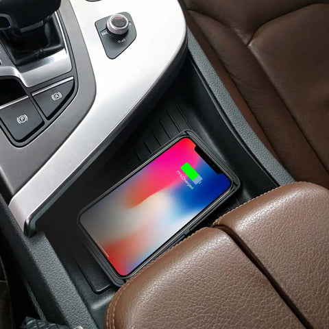 Smartphone charging wirelessly in a car, on a brown leather seat with a visible battery icon.