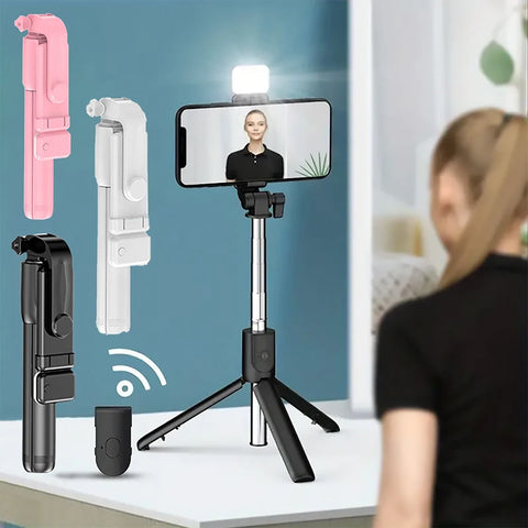 A woman uses a phone on a tripod with a ring light; pink, white, and black tripods shown.